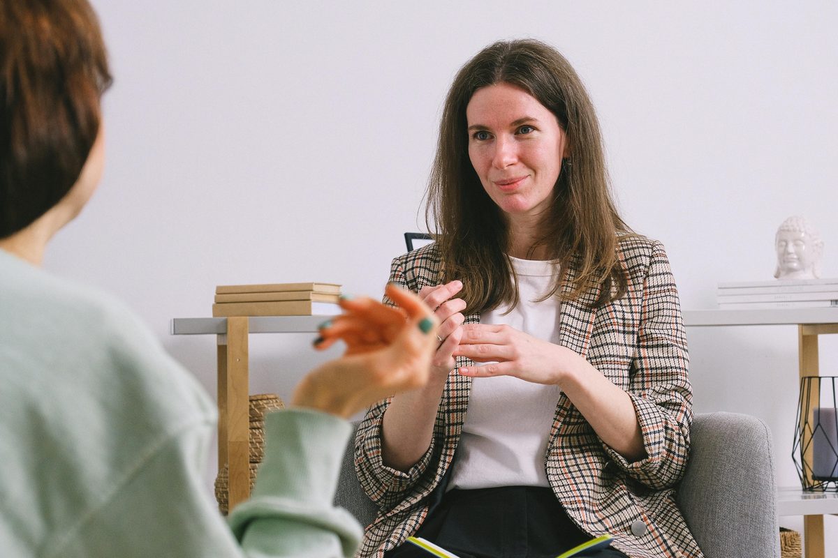Two people in a counseling conversation — in-house pastoral vs external professional referral