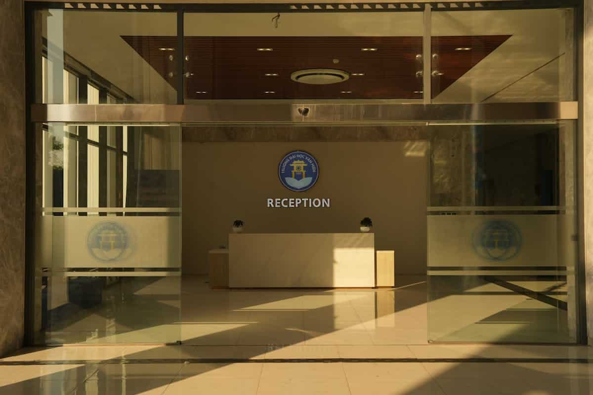 Modern office reception lobby — single controlled entry vs open campus